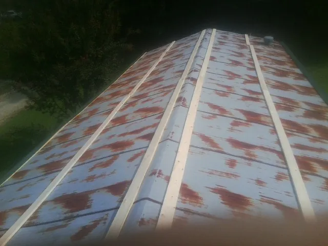 Rusted metal roof panels with new wood purlins before replacement — Storm Damage Roof Repair in Eggleston by Roofing Brothers