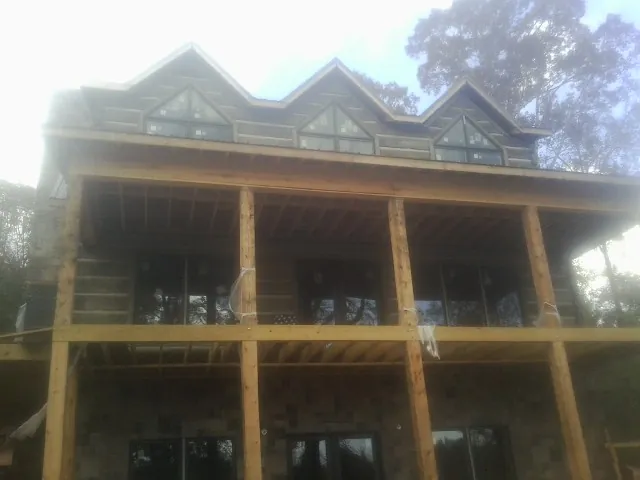 Dormers and porch framing on a large log home under construction — Roof Coating work by our crew in Eggleston