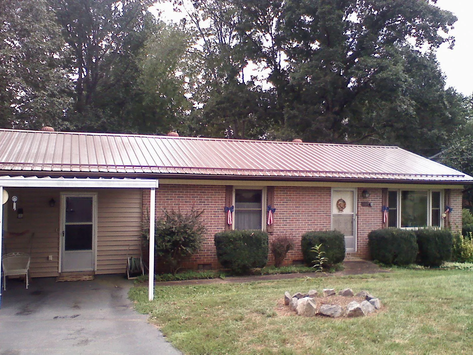 Bronze metal roof and carport on a brick ranch home — Roof Repair work by our crew in Eggleston